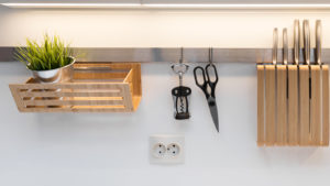 kitchenware hanging on the rail in the white glossy kitchen